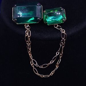 Vintage Costume emerald green glass double brooch pin with a gold-tone chain.